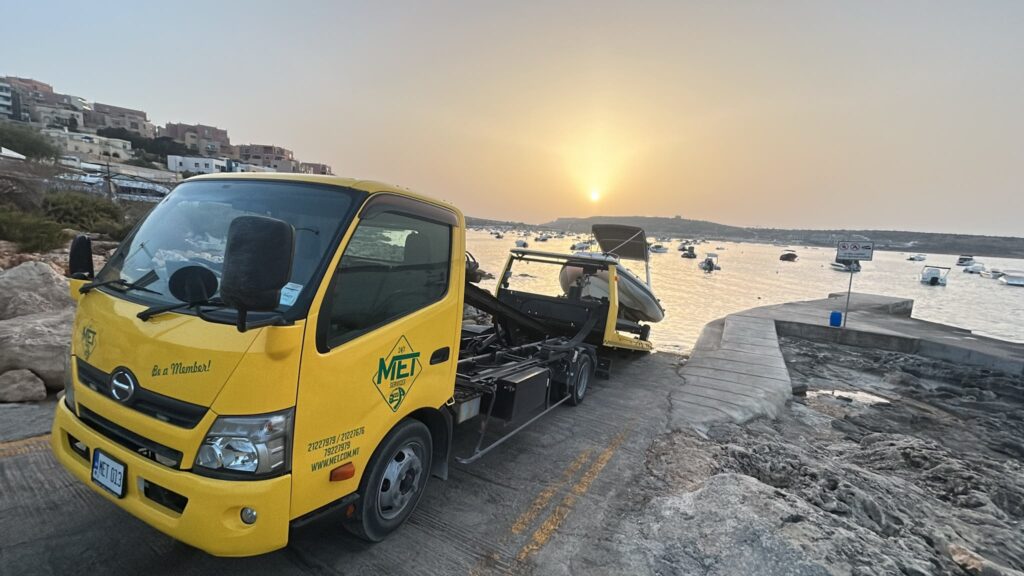 MET truck towing a sports car in a Maltese residential street